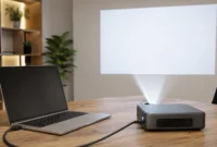 how-to-connect-projector-to-laptop-setup Laptop with HDMI cable connected to a compact projector casting a presentation onto a white wall in a modern workspace